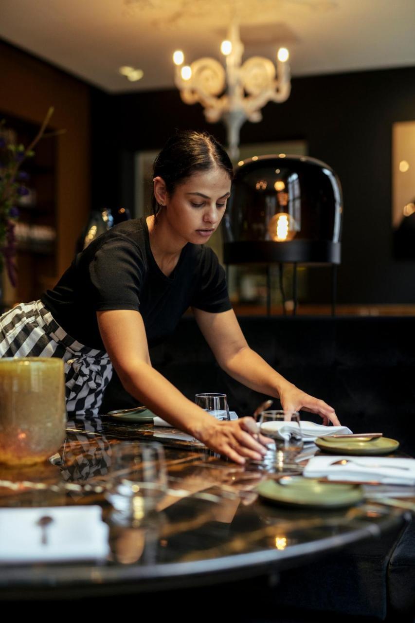 فندق هيت أريسثيس رورموند المظهر الخارجي الصورة A waitress clearing a table